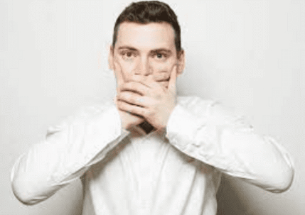 A man is holding his hands over his mouth